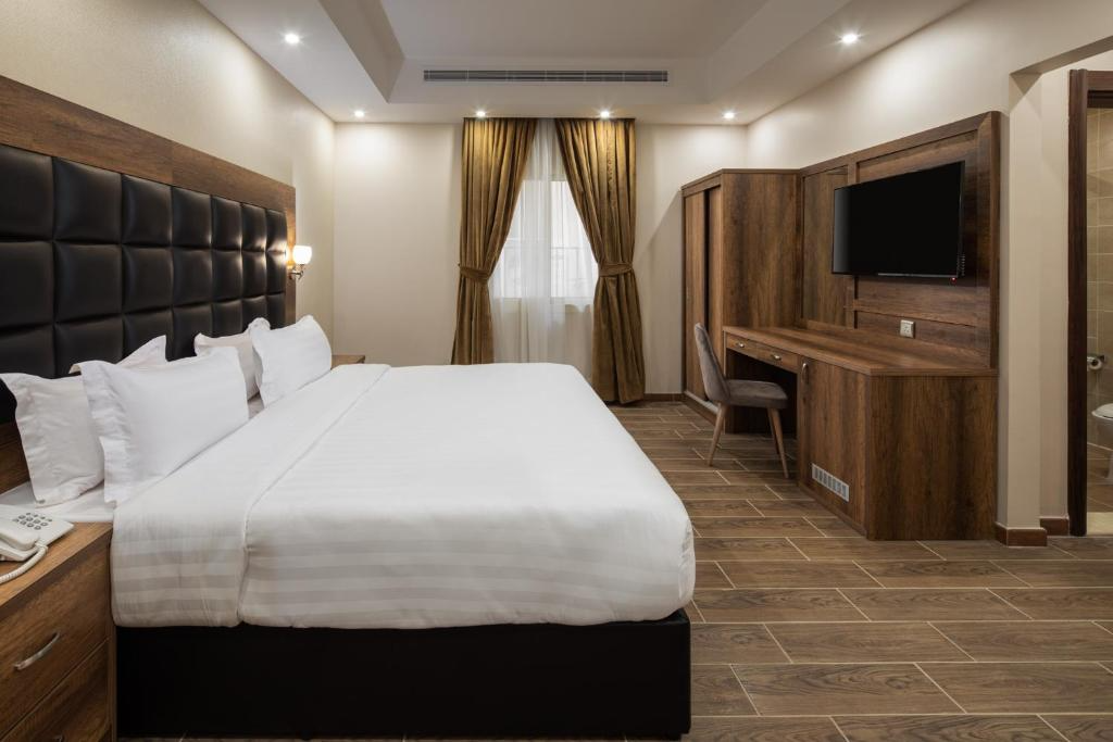 freepik__photo-a-hotel-room-with-a-large-bed-a-desk-a-tv-an__64314